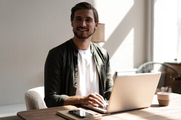 Male remote working from home and having work confrence video call. Freelancer working on laptop at home office.