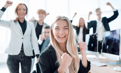 young woman on the background of a jubilant business team.