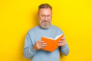 Photo of good mood man pensioner dressed blue pullover eyewear enjoying interesting story isolated yellow color background