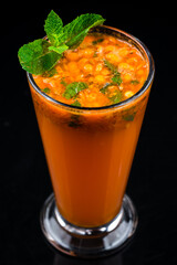 A glass of sea buckthorn tea on black background