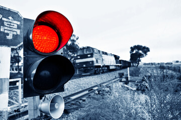 Chinese characters stop and traffic light shows red signal next to railway