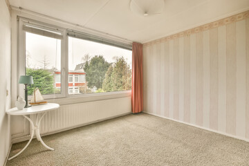 Empty room with wallpaper and brown curtains on windows