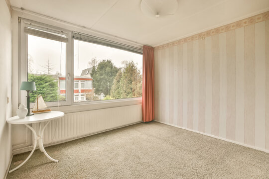 Empty room with wallpaper and brown curtains on windows