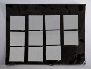 macro photo of black and white hand copy contact sheet with 11 empty film frames. 6x6 medium format film photo placeholder. real photo paper.