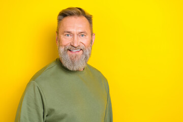 Obraz premium Photo of charming cheerful retired guy wear green sweater smiling empty space isolated yellow color background