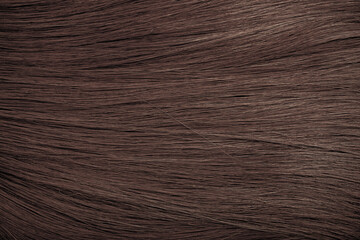 Brown hair close-up as a background. Women's long brown hair. Beautifully styled wavy shiny curls. Hair coloring. Hairdressing procedures, extension.