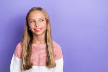 Photo portrait of cheerful satisfied girl interested look empty space dressed trendy pullover isolated on purple color background