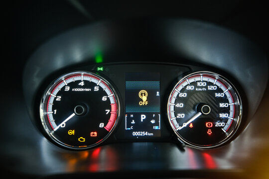 A low light picture with noise effect illuminated car speedometer with indicator.