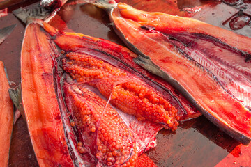 Opened salmon belly and fresh red caviar (eggs) inside the belly, close-up view, South Korea