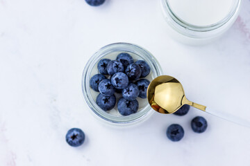 Homemade yogurt with blueberries. Top view on the white table