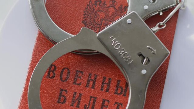 the military CARD of the Russian Federation with handcuffs rotates in a circle. Criminal punishment for military crimes