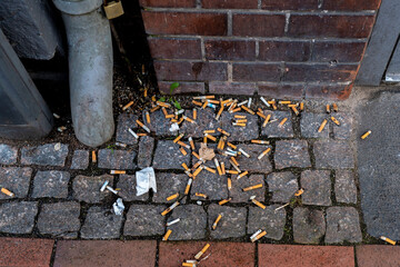 Cigarette butts thrown on sidewalk.