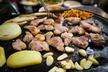 Jeju Black Pig meat grilling on a hot iron plate, restaurant in Jejudo (Jeju Island), South Korea