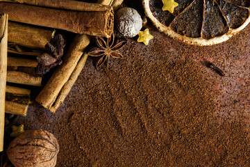 Christmas spices. Christmas composition with cinnamon sticks; anise stars, nutmeg, cloves, hazelnut and dried orange slices on dark background. Copy space for your text. Rustic vibe. - 535266198