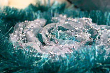 Christmas decorations of turquoise color. Silver beads on the background of a mint garland