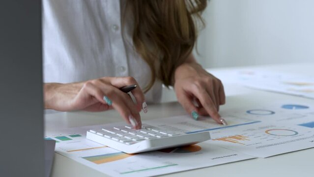 woman sit at desk calculates costs using calculator and laptop, close up view. Female manage expenditures, control personal expenses. Business accounting work concept.