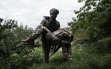 The commander carries a wounded soldier