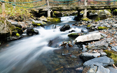 Old wooden bridge over small stream water