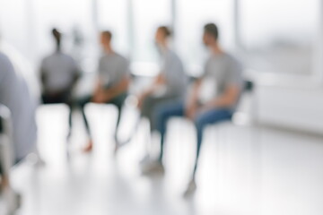 background image of a group of young people sitting in a circle. blurry image