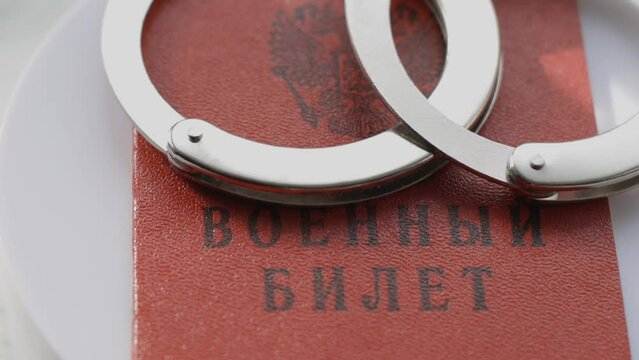 the military CARD of the Russian Federation with handcuffs rotates in a circle. Criminal punishment for military crimes