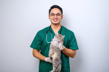 Smiling asian vet wearing green scrubs and stethoscope  holding cat