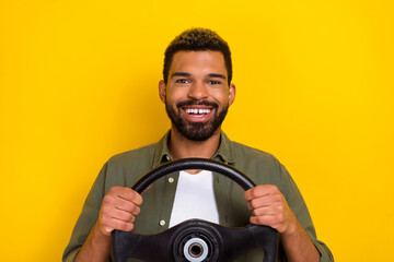 Photo of positive good mood man wear khaki shirt driving vehicle smiling isolated yellow color...