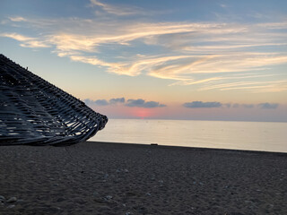Sunrise on the beach. Cloudy sky.  Beach umbrella.