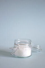 salt in a glass jar with a lid on a light blue background