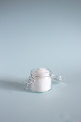 salt in a glass jar with a lid on a light blue background