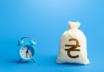 Time and ukrainian hryvnia money bag. Loans, mortgages. Retirement funds. ROI. Bonds, dividends....