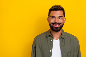 Photo of dreamy funky man wear khaki shirt looking empty space isolated yellow color background