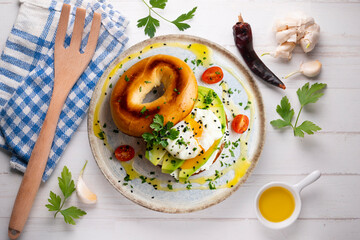 Toasted baggel with cream cheese, avocado, organic cherry tomatoes and poached egg. Vegan brunch.