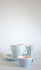 Fototapeta na wymiar three small blue coffee cups on a light blue background
