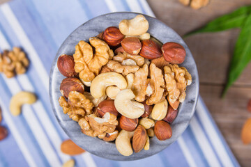 Marble bowl filled with shelled almonds, walnuts, cashew nuts
