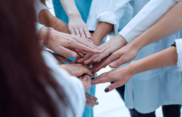 close up. a group of doctors putting their hands together.