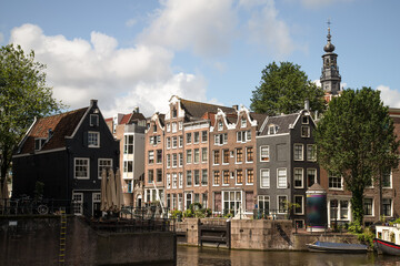 Narrow Amsterdam canal houses with the Sint Antoniesluis lock on the Oudeschans with the church...