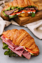 French croissant sandwich with lettuce , cheese , tomatoes and ham