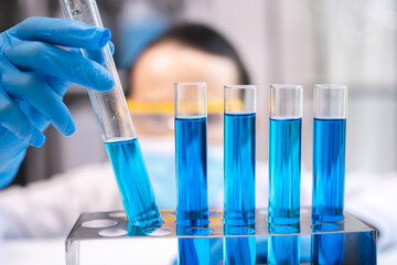 blue chemical liquid experiment in scientific glassware equipment in science medicine laboratory, chemistry or biology research discovery by using glass of test tube or beaker and flask