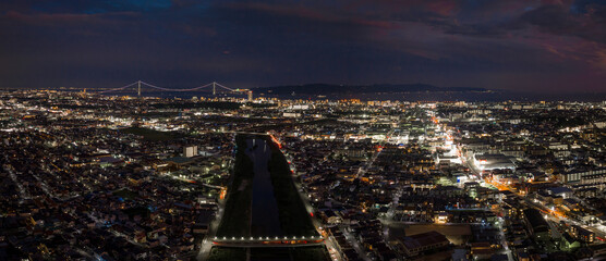 After sunset glow over city lights and distant suspension bridge 