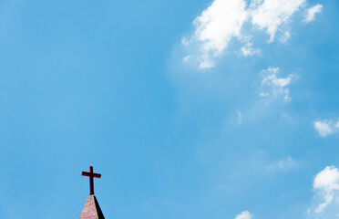 Christian cross on the rooftop against blue sky