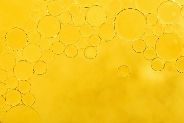 Bubbles of golden oil dissolve in water. Background of bubbles in free space for inscriptions