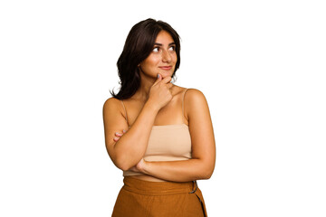 Young Indian woman isolated on green chroma background looking sideways with doubtful and skeptical expression. - obrazy, fototapety, plakaty