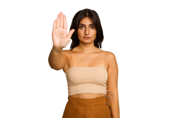 Young Indian woman isolated on green chroma background standing with outstretched hand showing stop sign, preventing you.