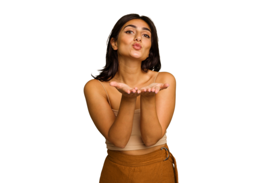 Young Indian woman isolated on green chroma background folding lips and holding palms to send air kiss.