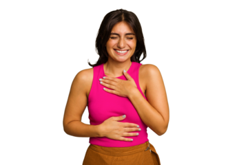 Young Indian woman isolated on green chroma background laughs happily and has fun keeping hands on stomach.