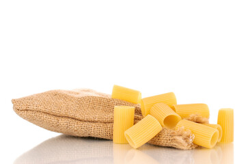 Several raw yellow cannelloni with a jute bag, macro, isolated on white background.