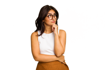 Young Indian woman isolated on green chroma background relaxed thinking about something looking at a copy space.