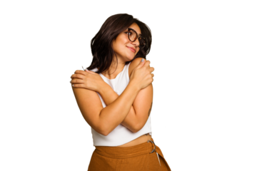 Young Indian woman isolated on green chroma background hugs, smiling carefree and happy.