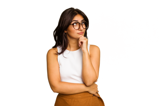 Young Indian woman isolated on green chroma background relaxed thinking about something looking at a copy space.