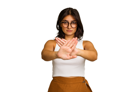 Young Indian woman isolated on green chroma background standing with outstretched hand showing stop sign, preventing you.